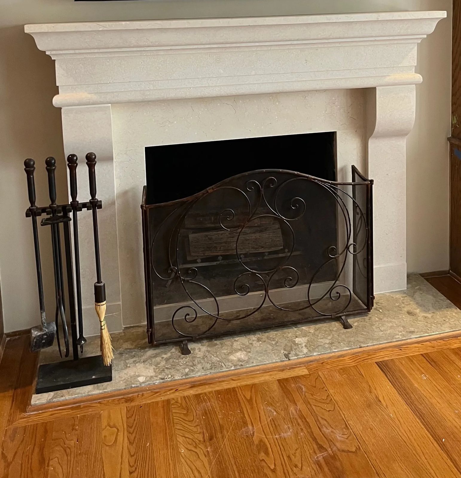 A classical limestone fireplace surround with a deep corbelled shelf and stepped mouldings.