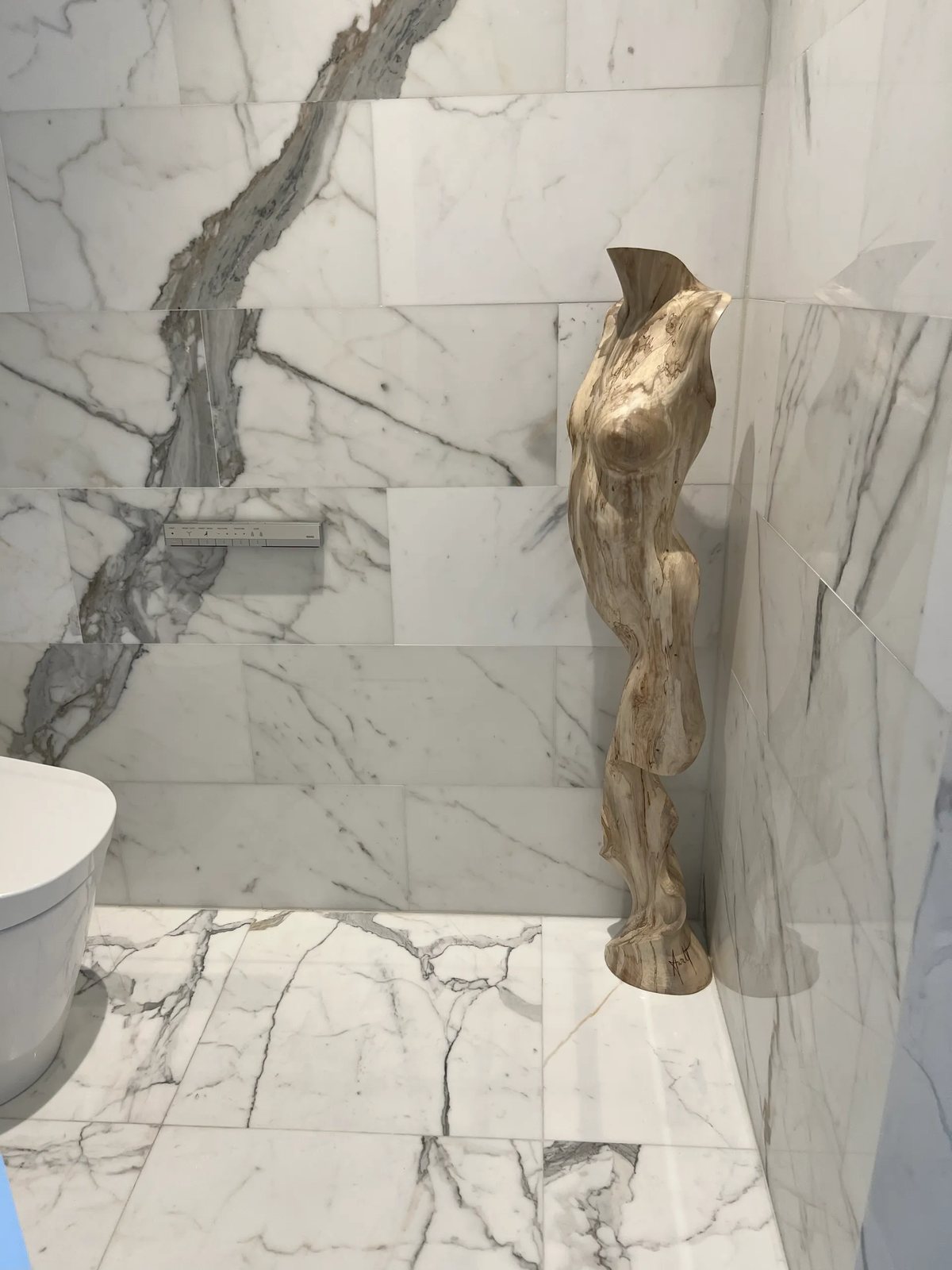 Bold-veined Calacatta marble on walls and floor, laid with matched veining.
