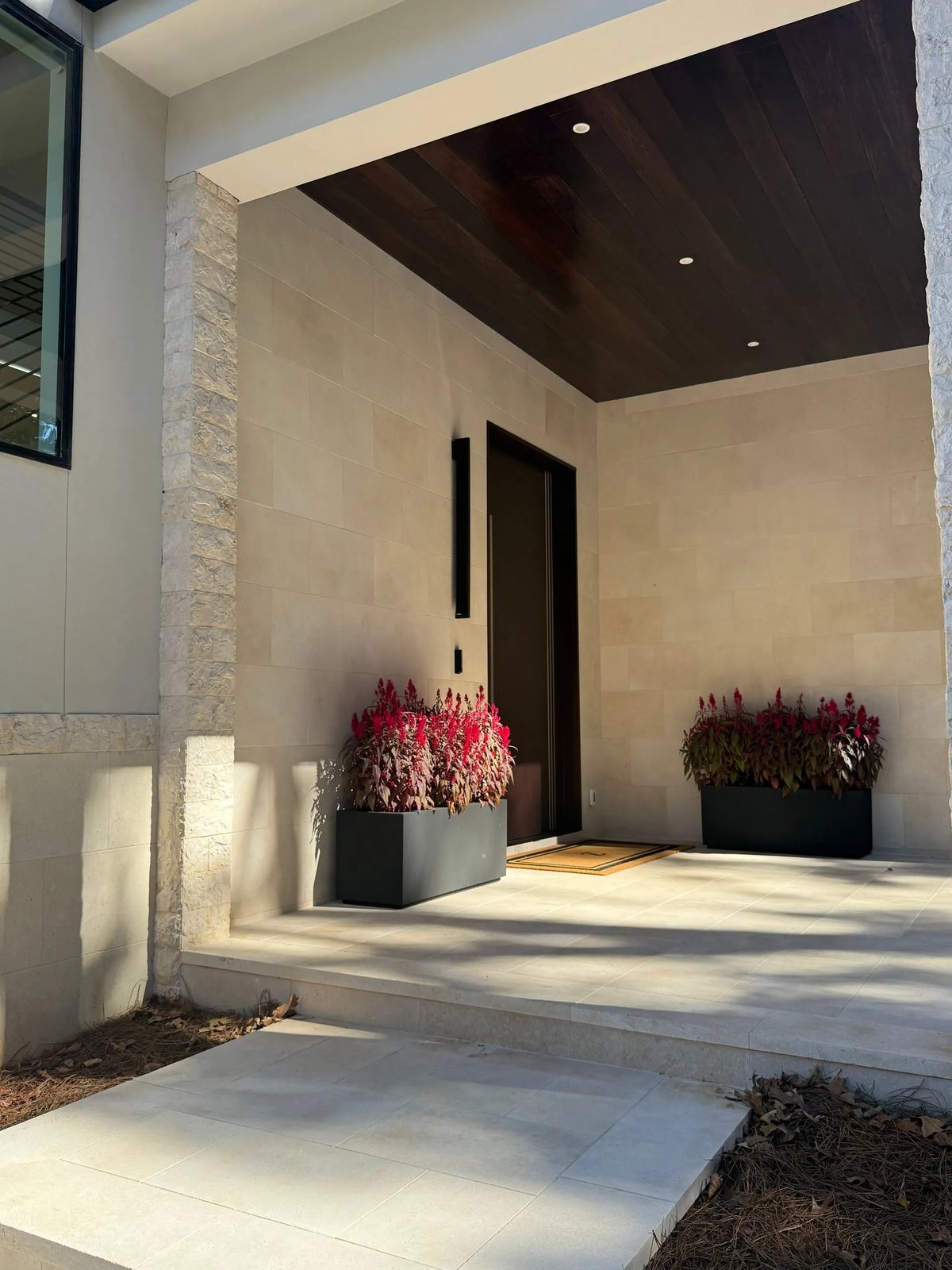 Smooth limestone wall cladding and paving at a covered entry