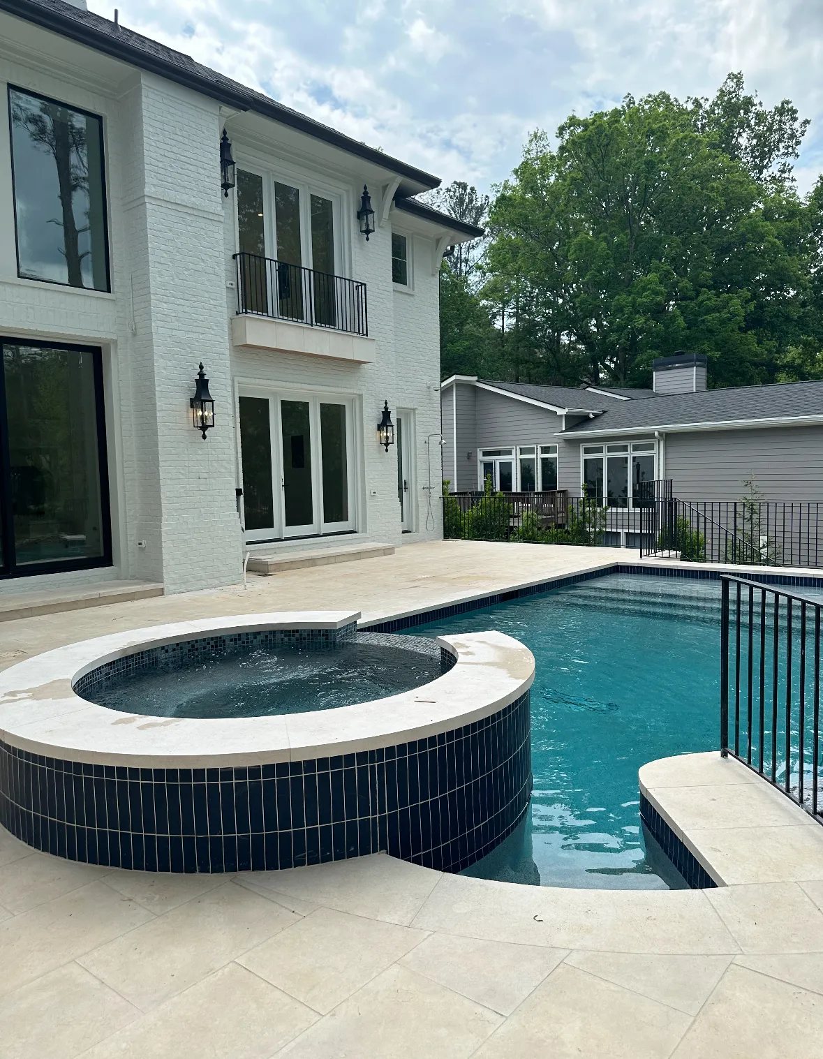 Bullnose limestone coping on a raised spa, with matching limestone pool decking.