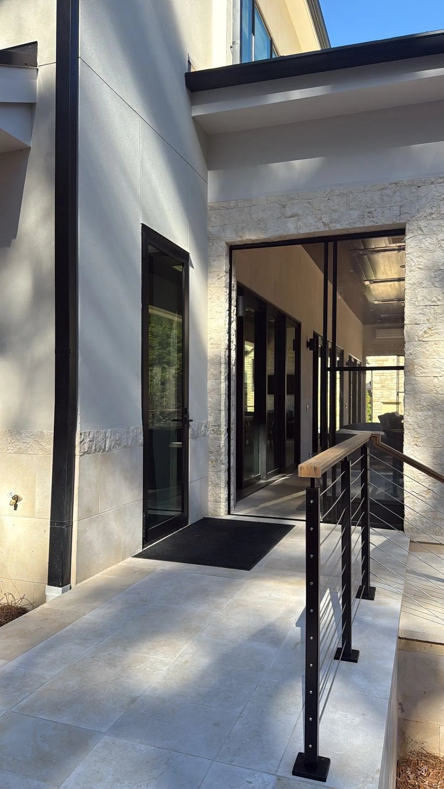Split-face limestone framing a glazed entry, with honed limestone paving and wainscot.