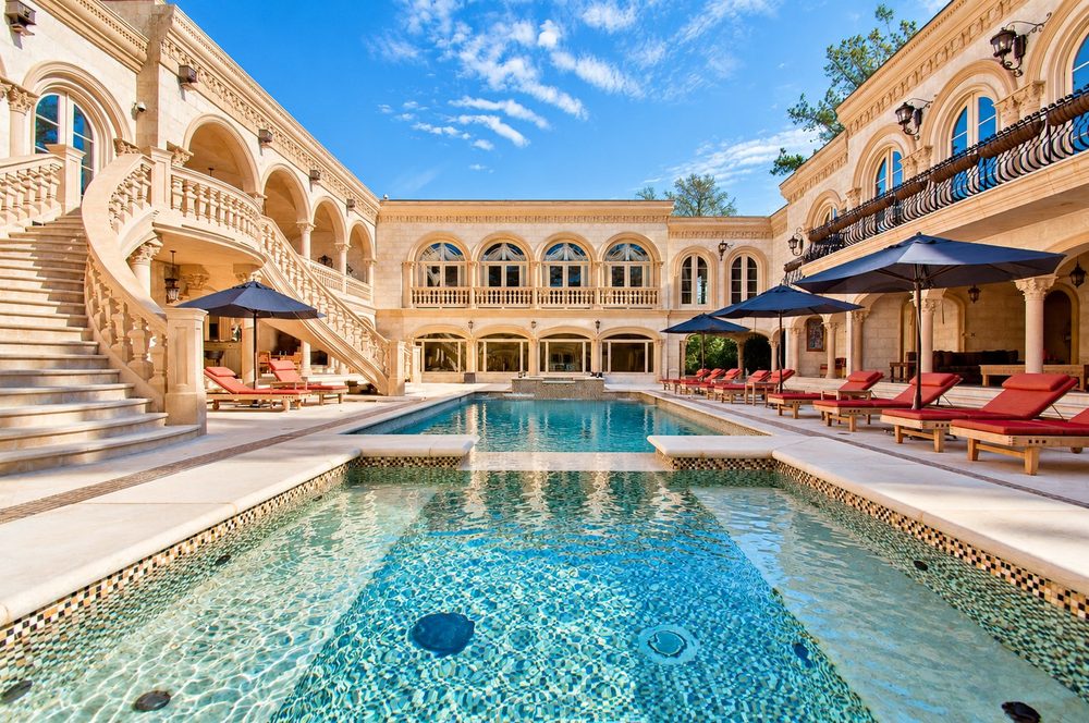 Limestone courtyard and mosaic-tiled pool framed by carved stone arches